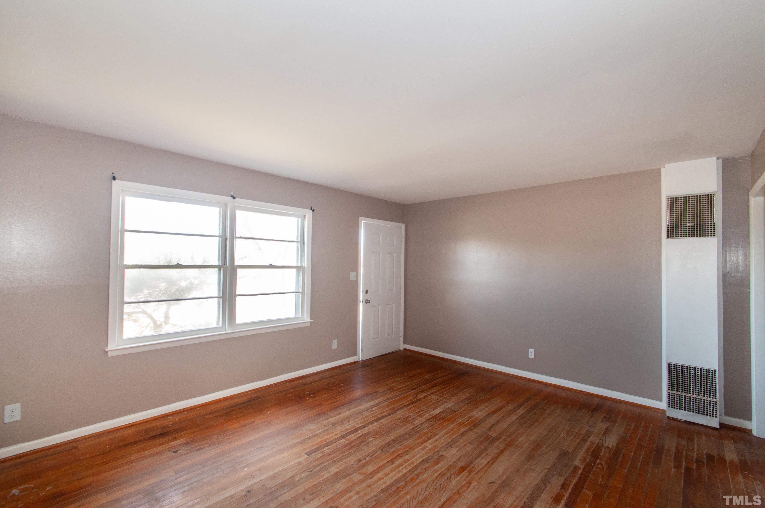 4260 Louisburg Road Raleigh, NC 27604 - Photo 5 of 22 an empty room with wooden floor and windows