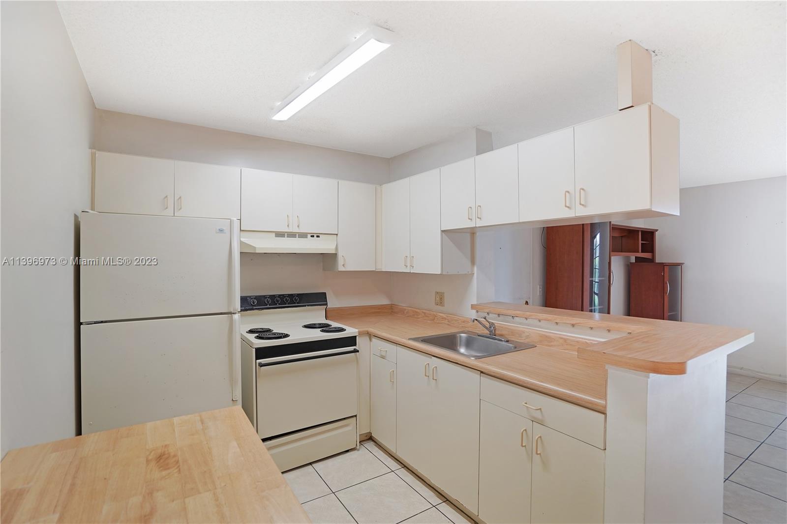9727 Hammocks Boulevard, Unit 103D Miami, FL 33196 - Photo 15 of 19 a kitchen with appliances and cabinets