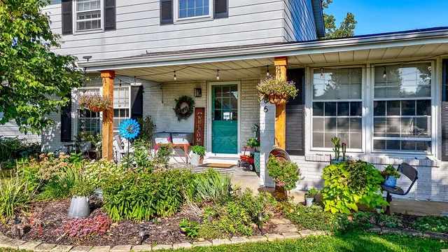 front view of a brick house with potted plants