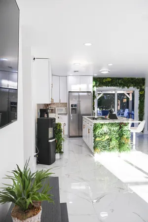 a kitchen with stainless steel appliances a refrigerator a stove a sink a dining table and chairs