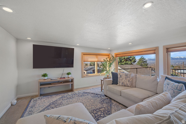 4426 South 3035 East Holladay, UT 84124 - Photo 13 of 49 Living room with carpet, recessed lighting, a textured ceiling, and a mountain view