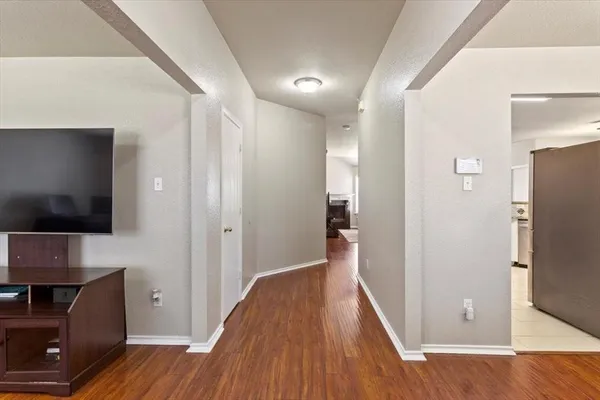 a view of a livingroom with wooden floor and a flat screen tv