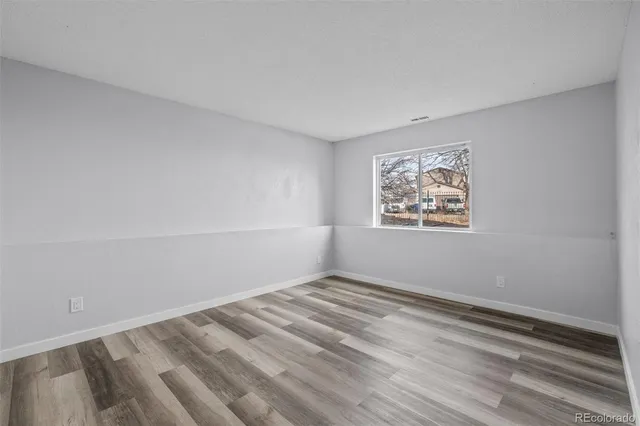 a view of empty room with wooden floor