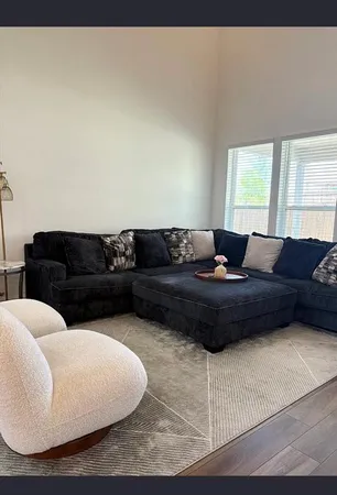 a living room with a couch wooden floor and a large window