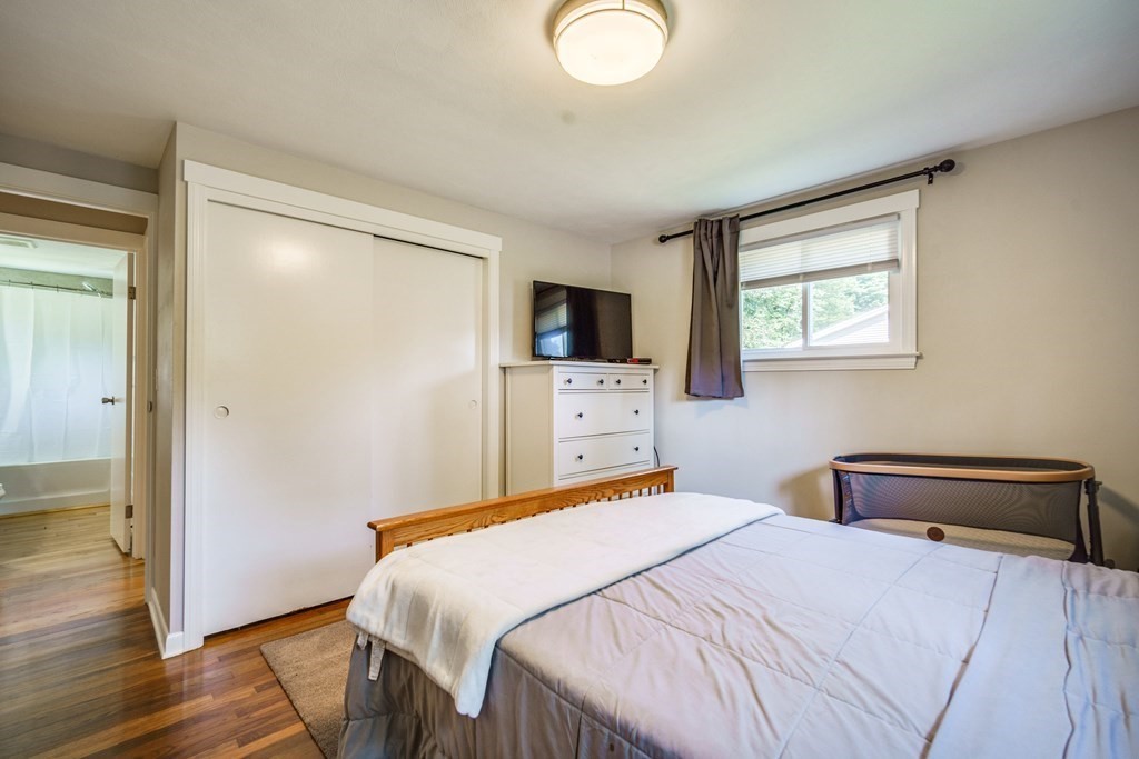 72 Wachusett Street Springfield, MA 01118 - Photo 17 of 28 a bedroom with a bed and wooden floor