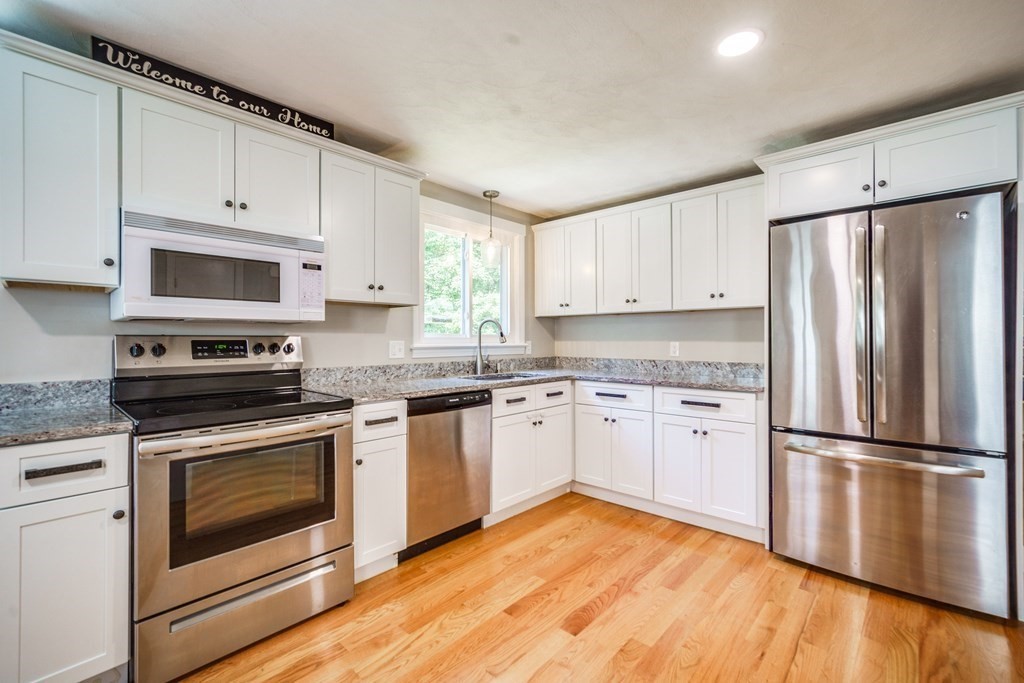 72 Wachusett Street Springfield, MA 01118 - Photo 7 of 28 a kitchen with granite countertop appliances cabinets and a wooden floor