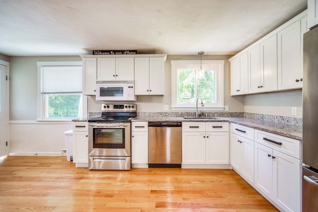 72 Wachusett Street Springfield, MA 01118 - Photo 8 of 28 a kitchen with granite countertop white cabinets appliances a sink and a window