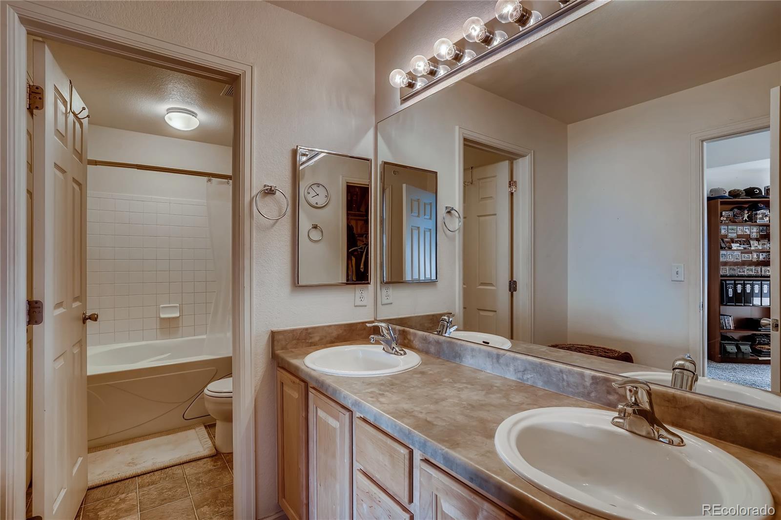 457 Black Feather Loop, Unit 709 Castle Rock, CO 80104 - Photo 7 of 11 a bathroom with a granite countertop sink a toilet a mirror and shower
