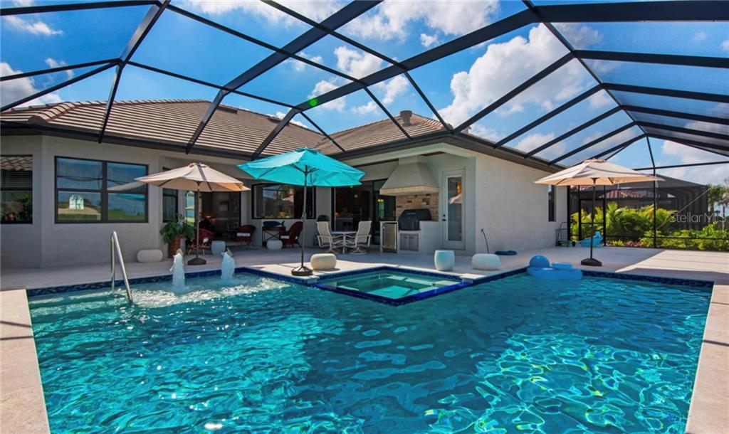 5543 Arnie Loop Bradenton, FL 34211 - Photo 11 of 45 a view of a backyard with table and chairs under an umbrella