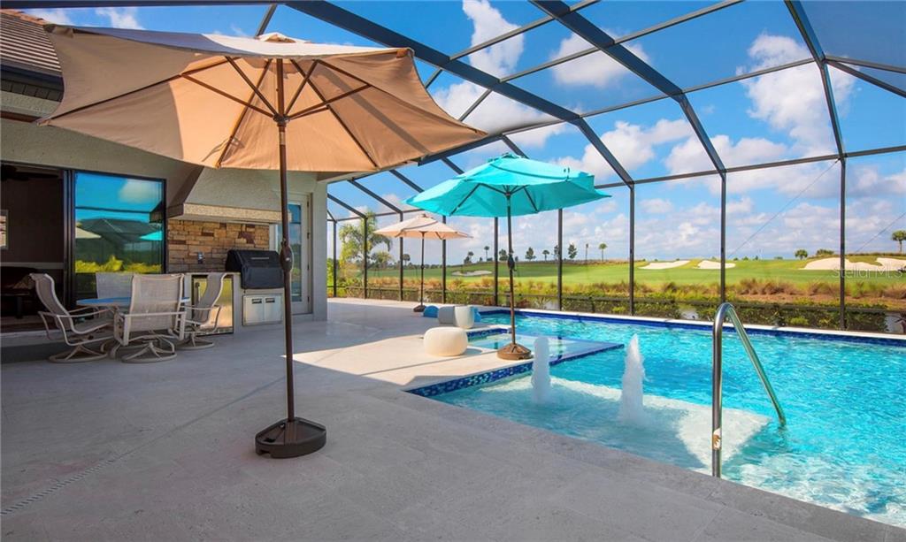 5543 Arnie Loop Bradenton, FL 34211 - Photo 17 of 45 a view of a swimming pool with a table and chairs under an umbrella