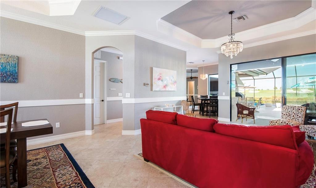 5543 Arnie Loop Bradenton, FL 34211 - Photo 25 of 45 a living room with furniture and a chandelier