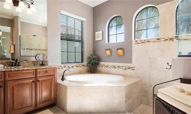 a bathroom with a granite countertop sink a large mirror and a shower