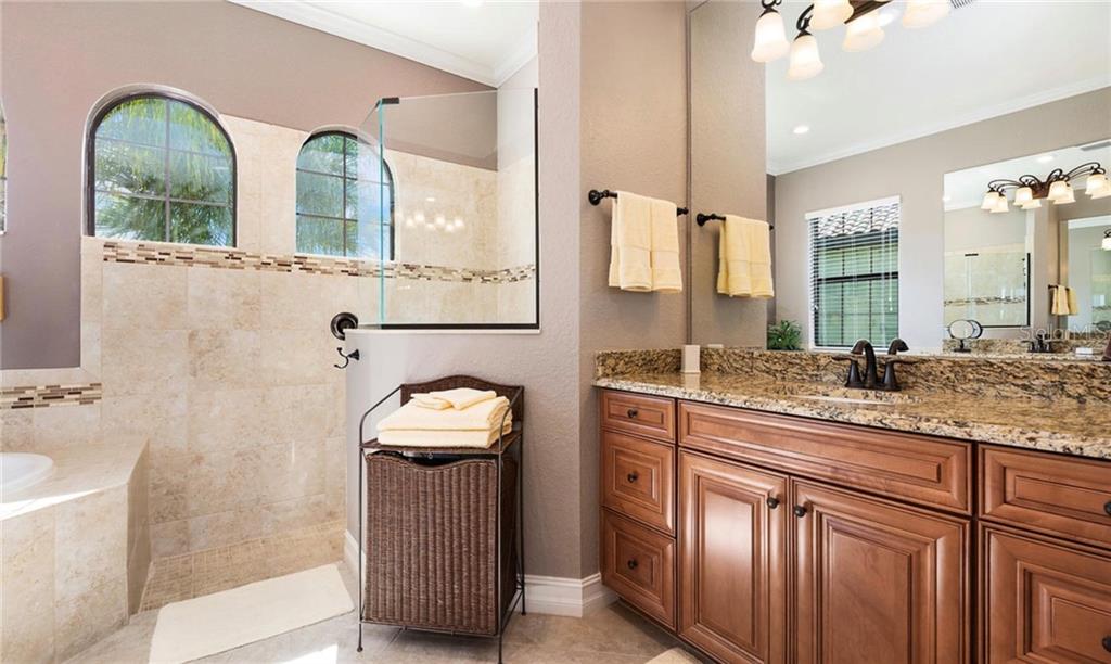 5543 Arnie Loop Bradenton, FL 34211 - Photo 32 of 45 a bathroom with a granite countertop sink a large mirror and a shower