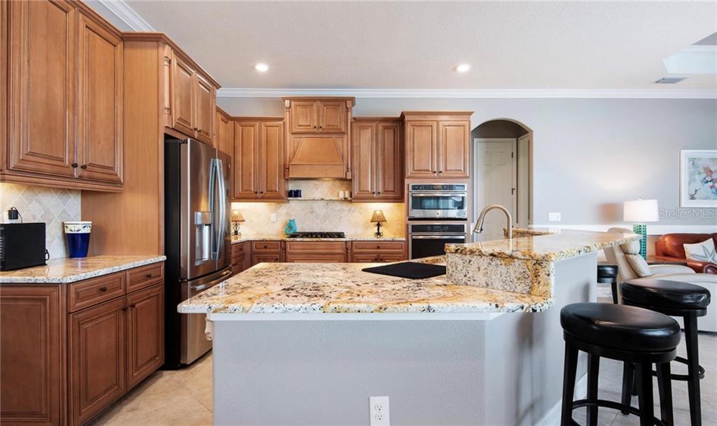 5543 Arnie Loop Bradenton, FL 34211 - Photo 35 of 45 a kitchen with kitchen island granite countertop a sink stove and refrigerator