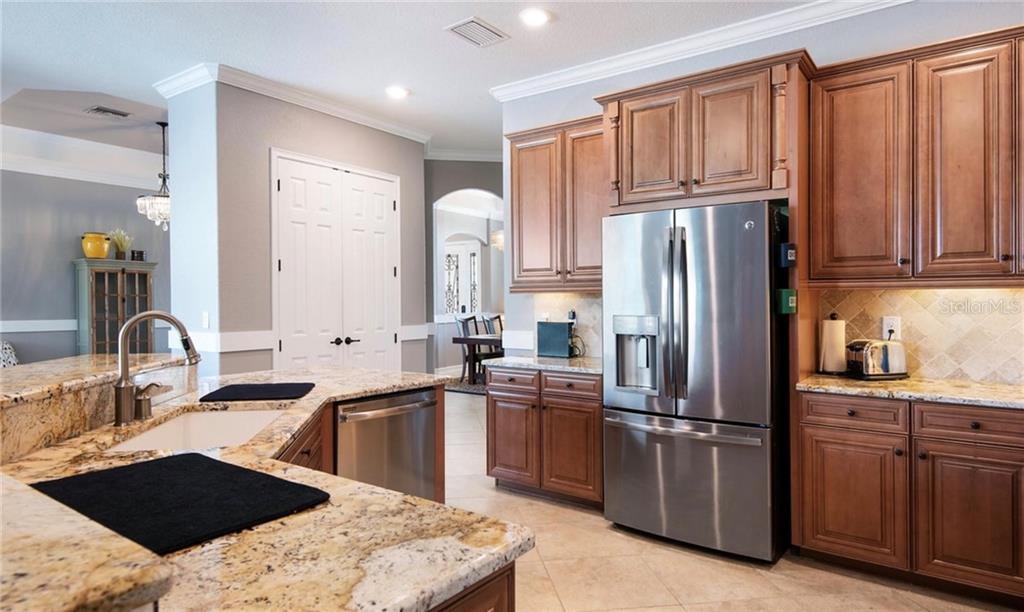 5543 Arnie Loop Bradenton, FL 34211 - Photo 37 of 45 a kitchen with stainless steel appliances granite countertop a sink stove and refrigerator