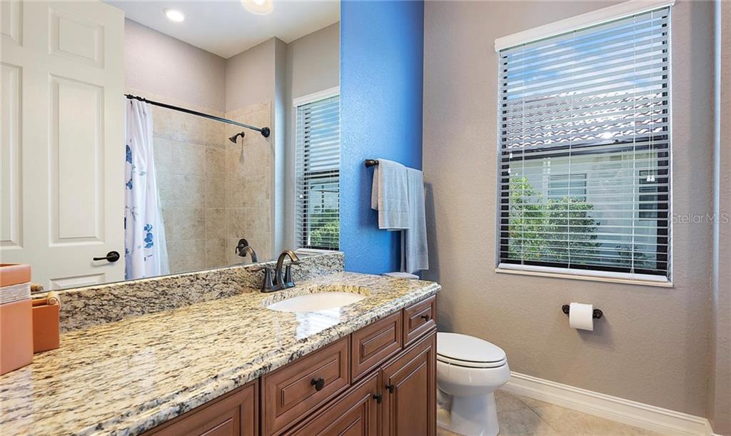 5543 Arnie Loop Bradenton, FL 34211 - Photo 40 of 45 a bathroom with a granite countertop sink toilet and shower