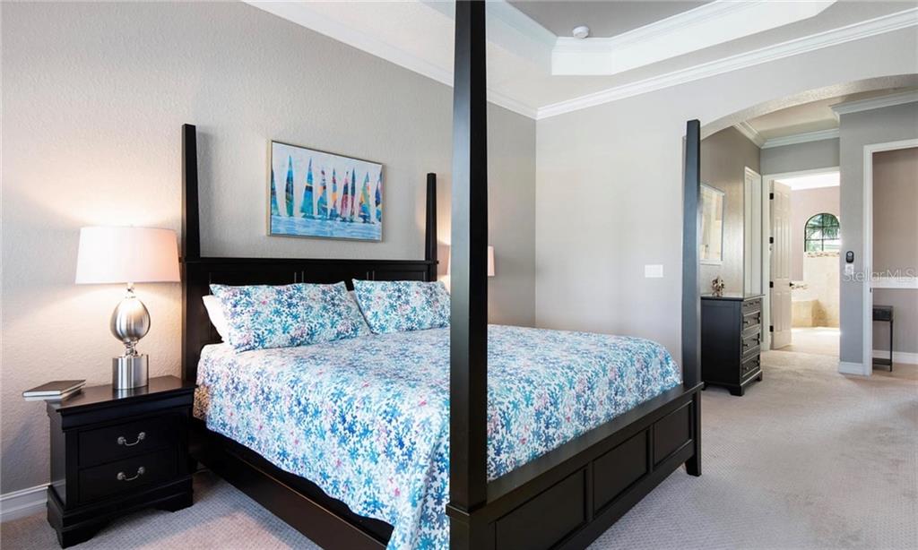 5543 Arnie Loop Bradenton, FL 34211 - Photo 4 of 45 a bedroom with a bed and a night stand