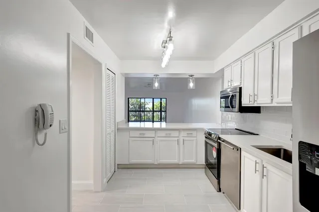 a view of a kitchen with a sink and a refrigerator