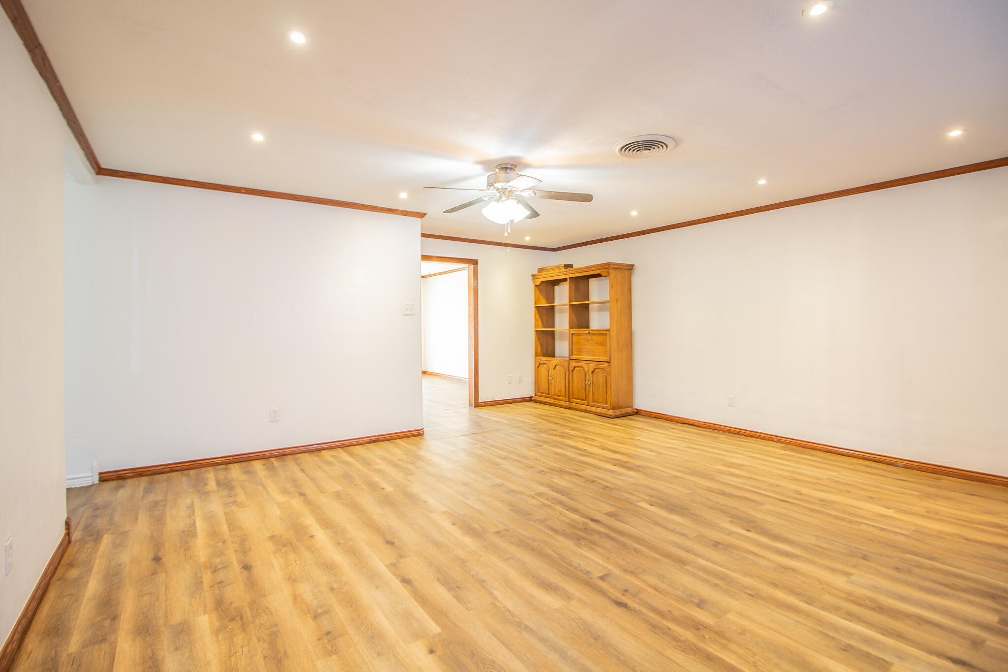 5503 9th Street Lubbock, TX 79416 - Photo 6 of 31 a view of empty room with wooden floor and fan