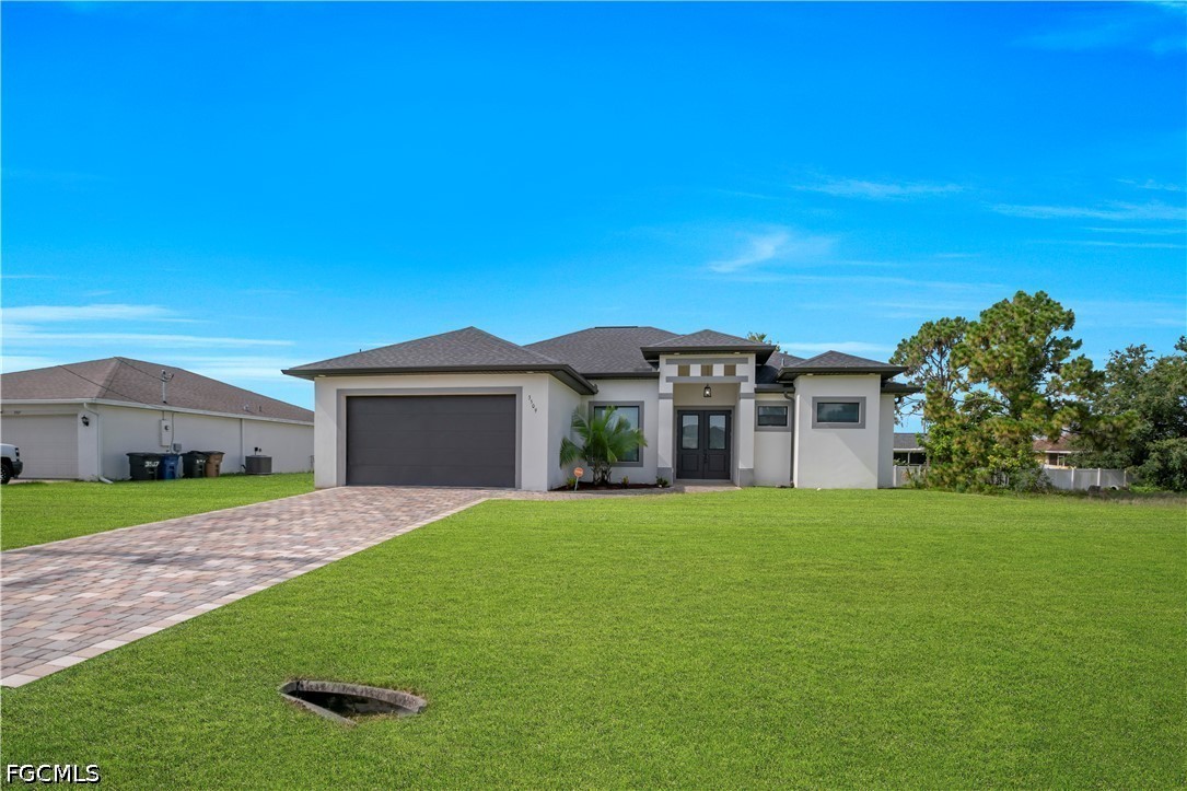 3509 38th Street Southwest Lehigh Acres, FL 33976 - Photo 2 of 47 a front view of a house with a yard and garage
