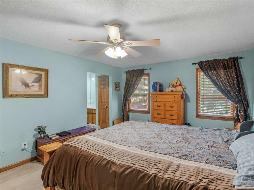 5 Ridgewood Circle McDonough, GA 30252 - Photo 13 of 20 a bedroom with a large bed and a chandelier