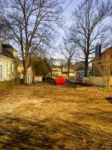 a yellow building in the middle of a yard