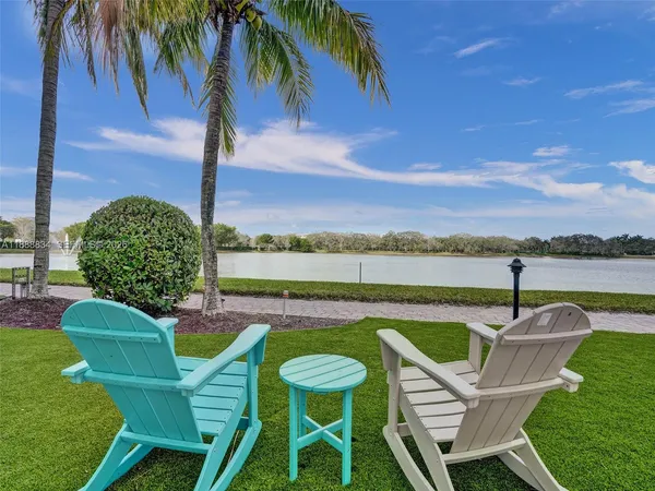 a view of a chairs and table in patio with a lake view
