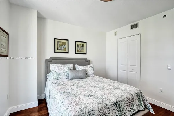 a bedroom with a bed and painting on the wall