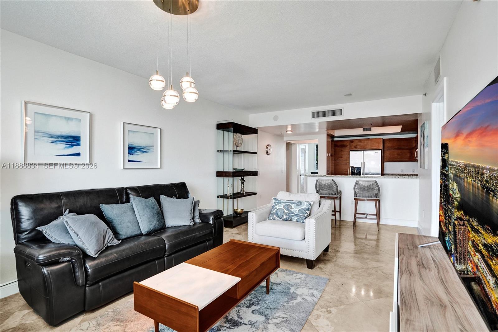 2681 North Flamingo Road, Unit 605S Sunrise, FL 33323 - Photo 4 of 47 a living room with furniture a rug and a flat screen tv