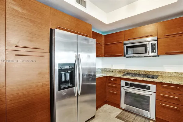 a kitchen with stainless steel appliances granite countertop a refrigerator and a stove top oven
