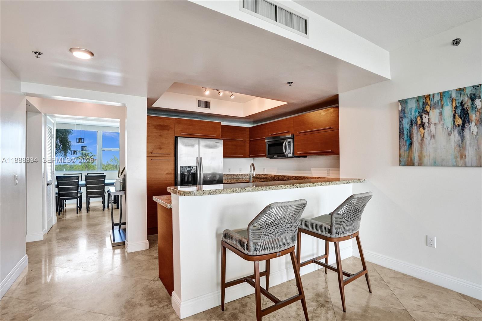 2681 North Flamingo Road, Unit 605S Sunrise, FL 33323 - Photo 9 of 47 a kitchen with stainless steel appliances granite countertop table chairs and a refrigerator