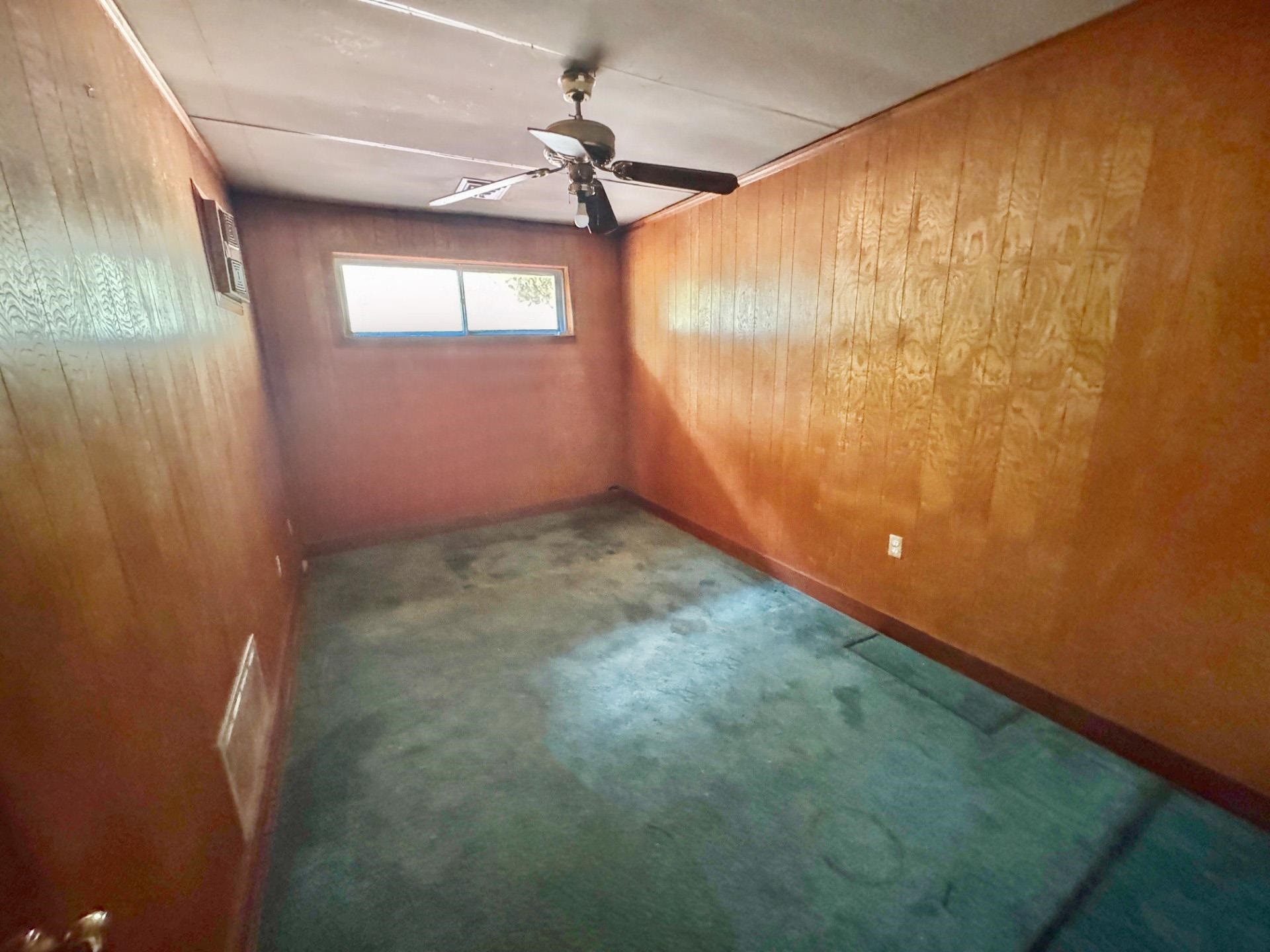 6014 Raleigh Lagrange Road Memphis, TN 38134 - Photo 13 of 19 Unfurnished room featuring wood walls and a ceiling fan