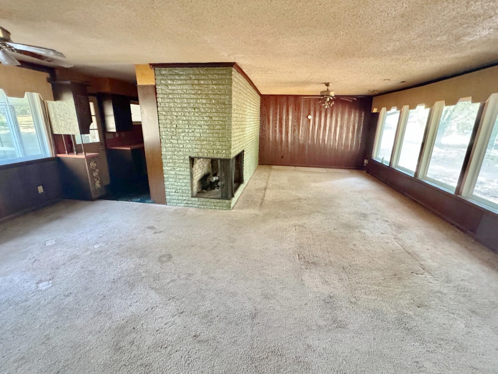 6014 Raleigh Lagrange Road Memphis, TN 38134 - Photo 9 of 19 Unfurnished living room featuring ceiling fan, carpet floors, a textured ceiling, and a fireplace