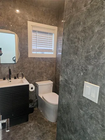 a bathroom with a toilet sink and mirror