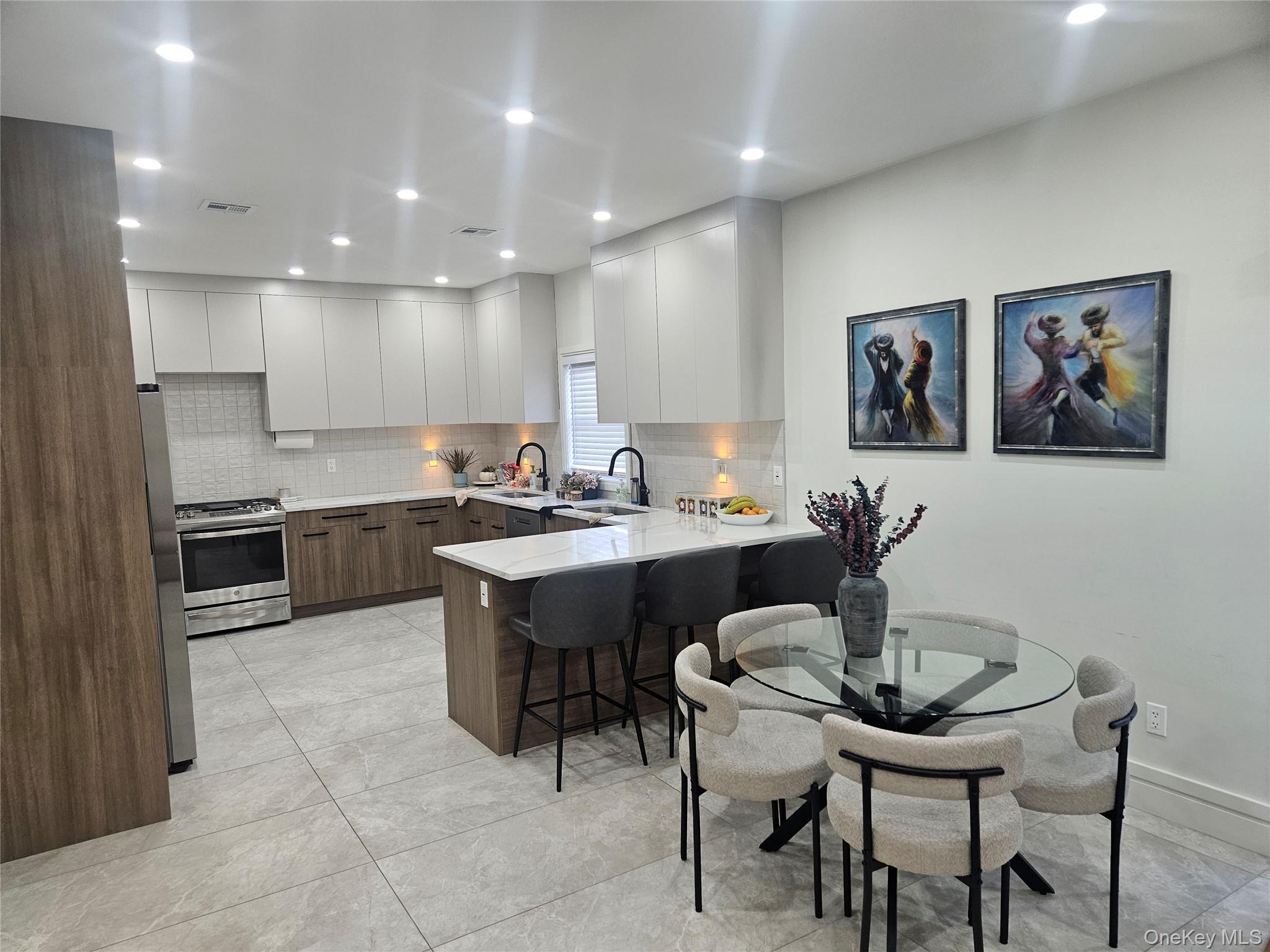 344 Bayview Avenue Inwood, NY 11096 - Photo 7 of 12 a kitchen with a table chairs sink and cabinets