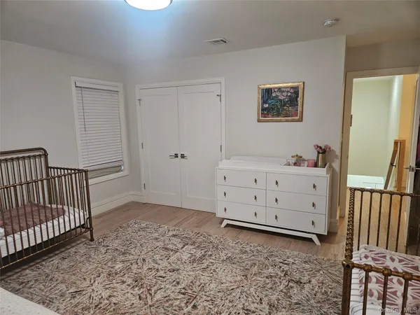 a view of a bedroom with furniture and wooden floor
