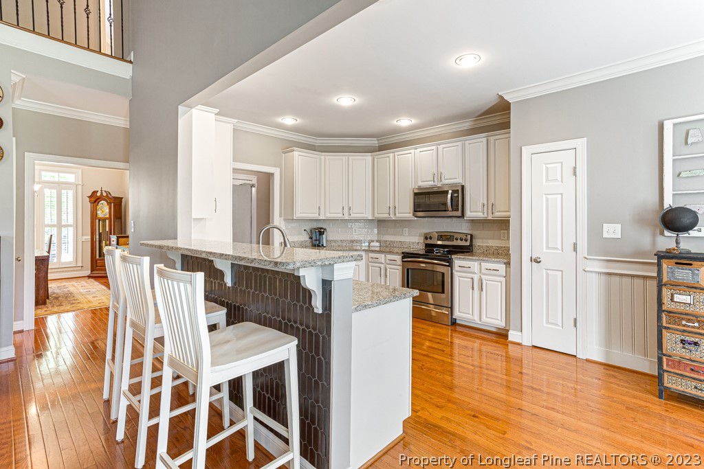 645 Little Bridge Road Fayetteville, NC 28311 - Photo 14 of 49 a kitchen with stainless steel appliances granite countertop a stove top oven a sink a dining table and chairs