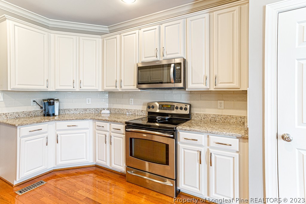 645 Little Bridge Road Fayetteville, NC 28311 - Photo 19 of 49 a kitchen with granite countertop white cabinets and stainless steel appliances