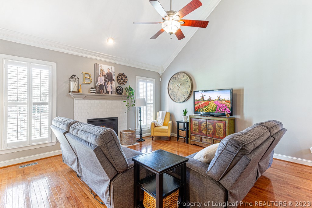 645 Little Bridge Road Fayetteville, NC 28311 - Photo 10 of 49 a living room with furniture a clock and a fireplace