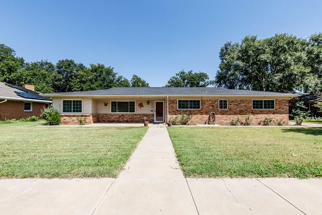 front view of house with a yard and potted plants