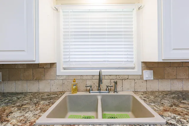 a kitchen with granite countertop white cabinets and white appliances