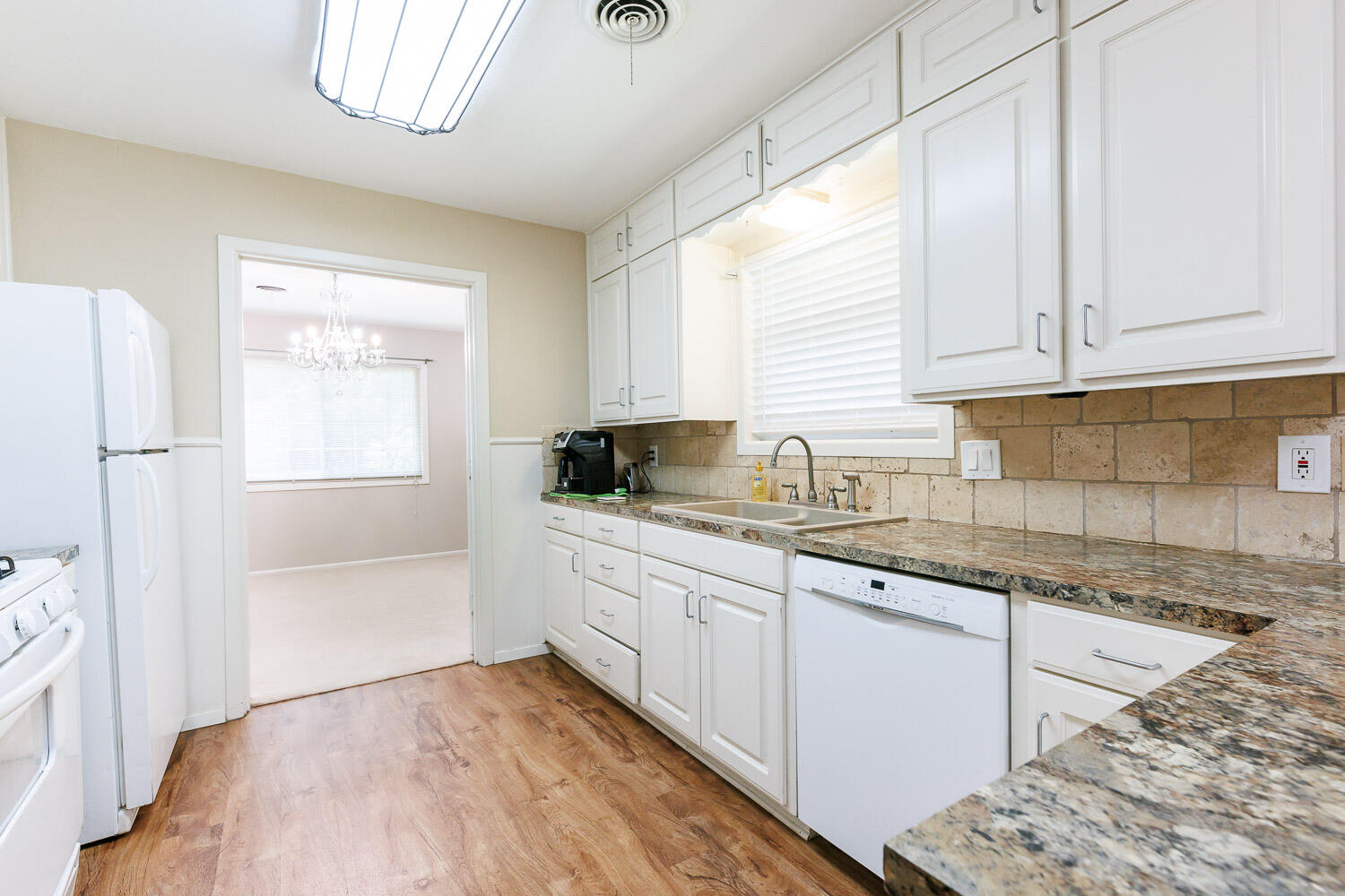 3816 53rd Street Lubbock, TX 79413 - Photo 17 of 59 a kitchen with granite countertop white cabinets and white appliances