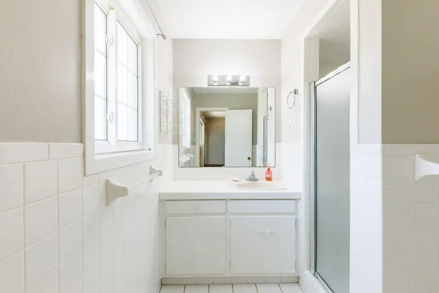 a bathroom with a granite countertop sink toilet and shower