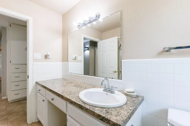 a bathroom with a granite countertop sink toilet and a mirror