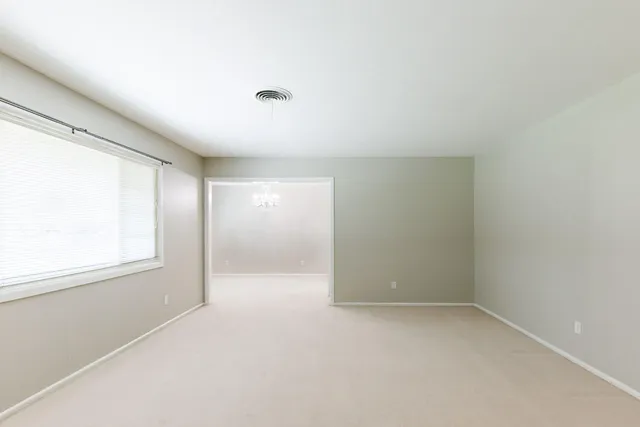 a view of a hallway with wooden floor and a living room
