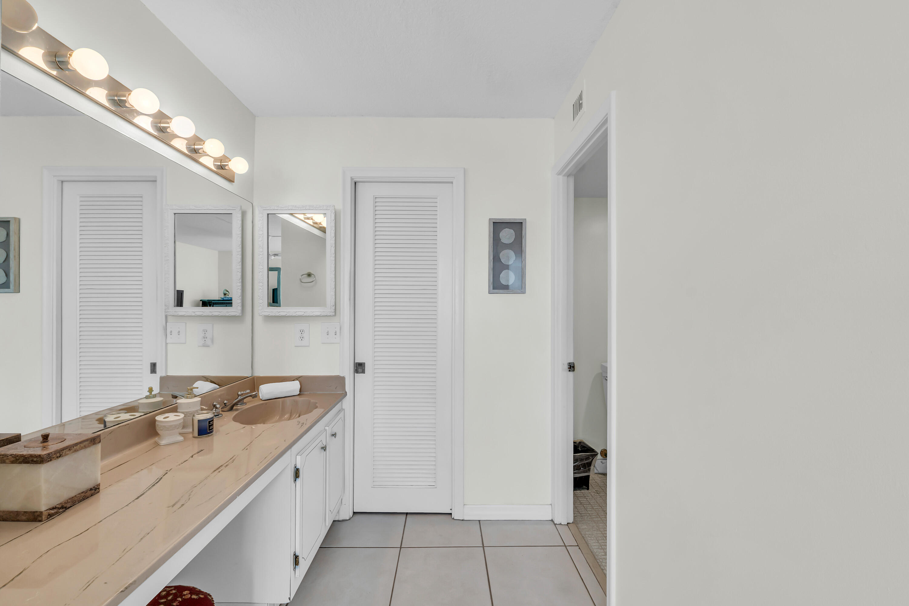 4 Royal Palm Way, Unit 601 Boca Raton, FL 33432 - Photo 21 of 34 a bathroom with a granite countertop sink and a mirror