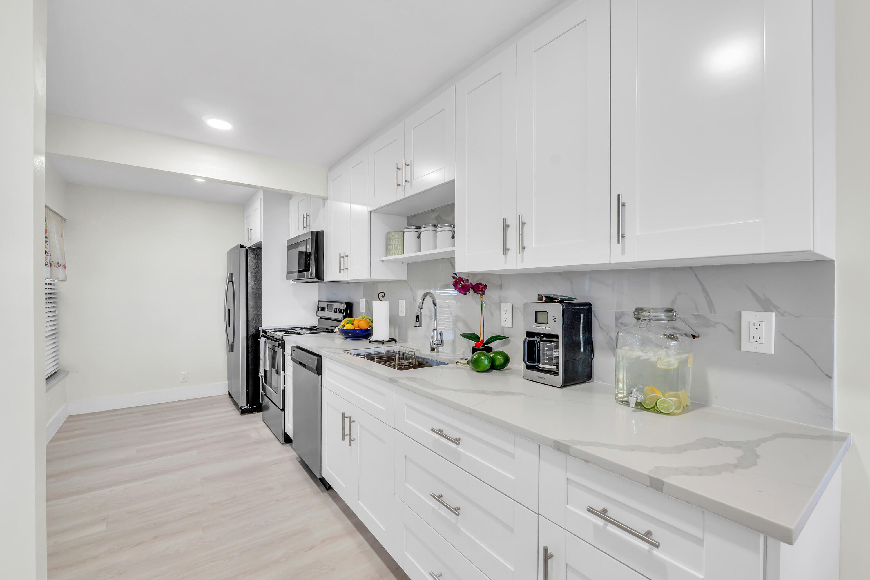 4 Royal Palm Way, Unit 601 Boca Raton, FL 33432 - Photo 6 of 34 a kitchen with a sink a refrigerator and cabinets