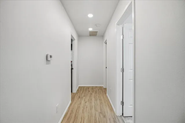 a view of a hallway with wooden floor and staircase