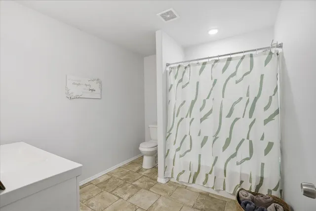 a bathroom with a shower curtain and a toilet