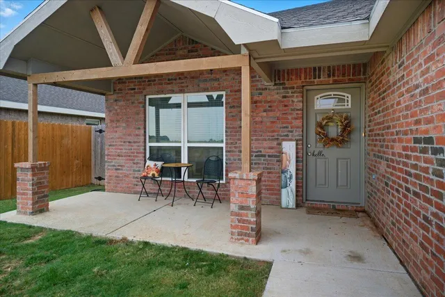 a view of a door with a chairs and table in a patio